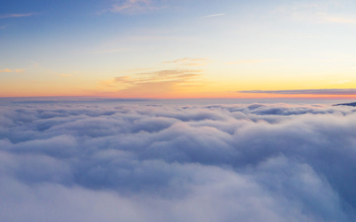 美丽的日出从鸟瞰图多云的天空。飞机上面查看云